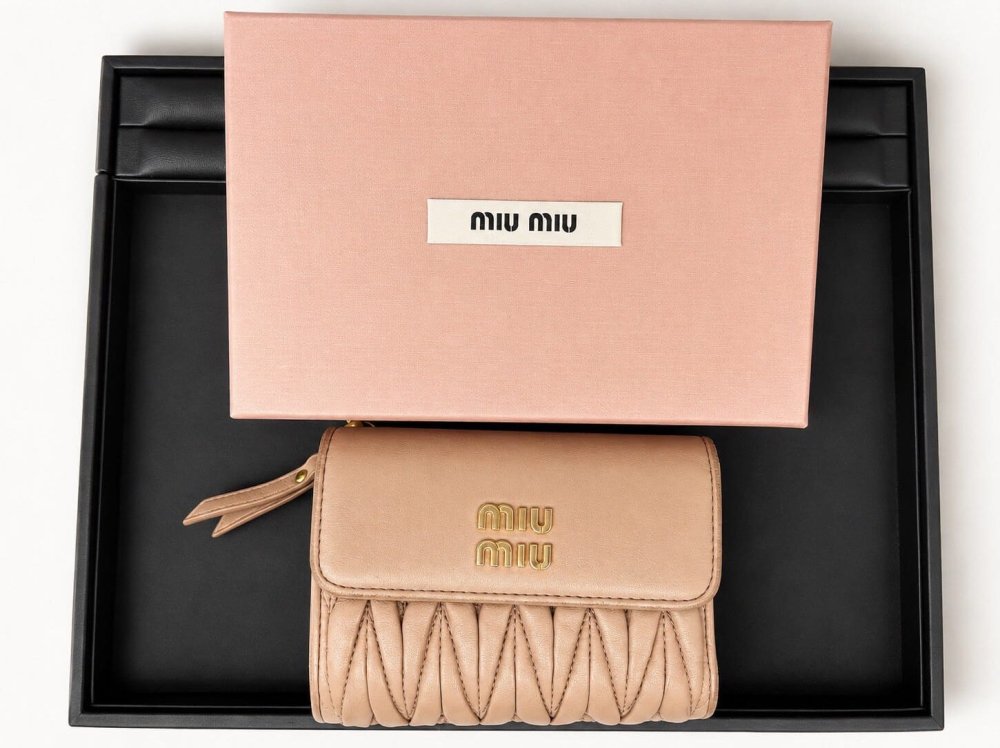 ミュウミュウ(miu miu)のピンクベージュのマトラッセレザー財布とピンクのギフトボックス"